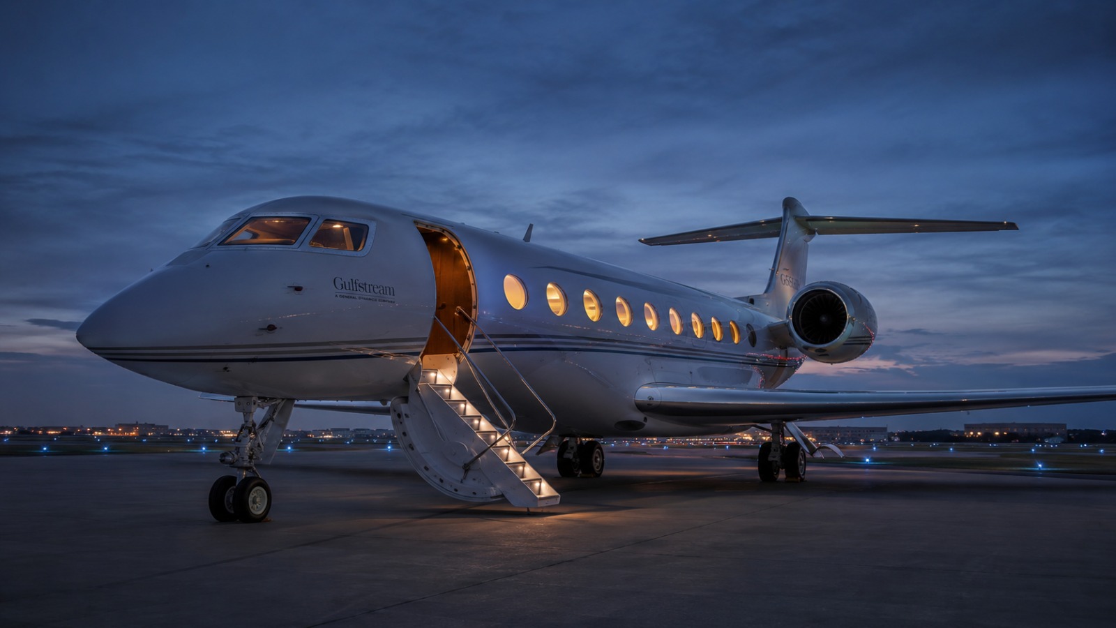 A private jet on the apron at dusk with the airstair lowered